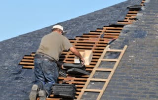 Roofer posing slate on a roof