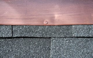 Black asphalt roofing shingles with copper flashing
